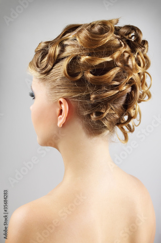 Young woman with beautiful hairstyle on gray