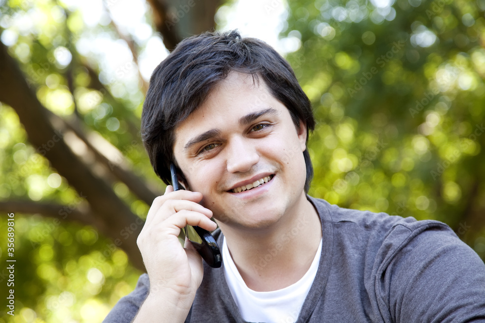 Beautiful brunette men calling by mobile at outdoor. Beautiful brunette men calling by mobile at outdoor.