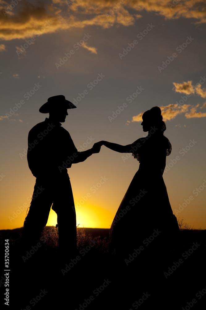 Cowboy couple silhouette hold hands