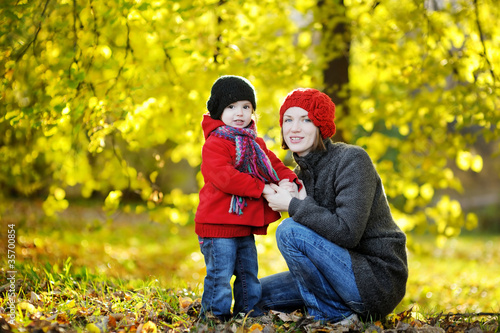 Young mother and her toddler girl in autumn