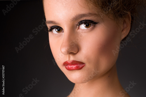 Close-up portrait of serious-looking woman on a black background