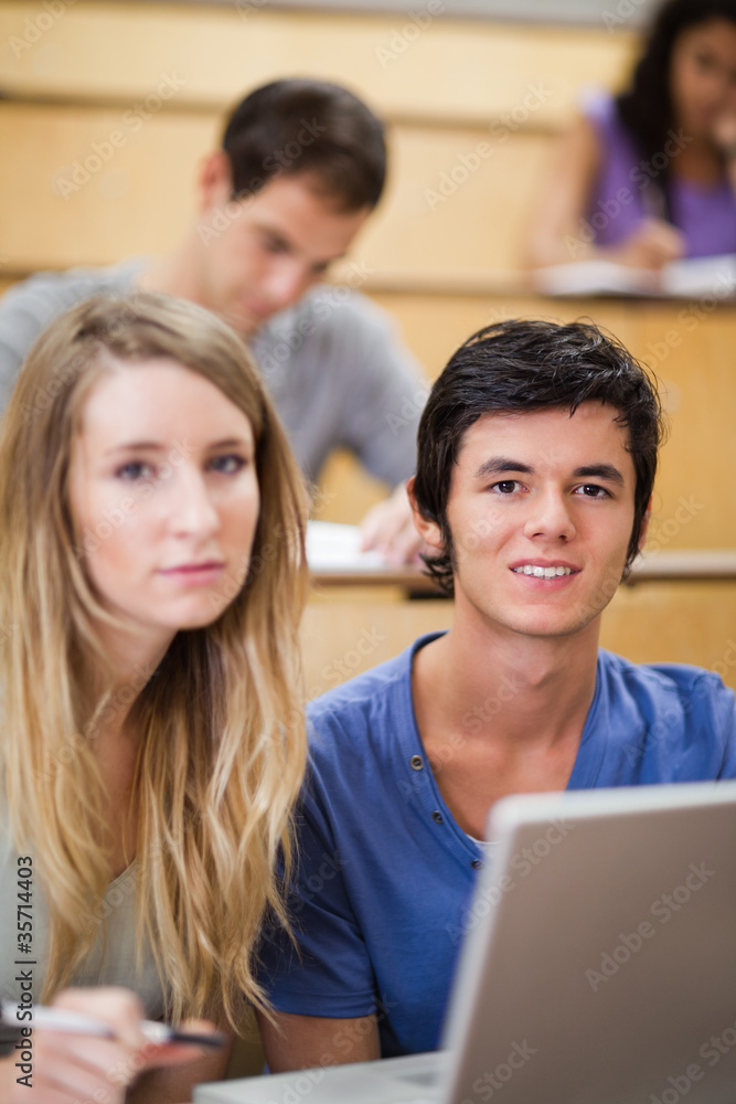 Portrait of young students posing with a laptop Portrait of young students posing with a laptop