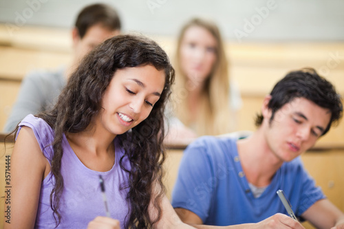 Smiling students writing