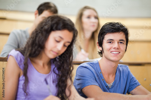 Student being distracted while his classmates are listening