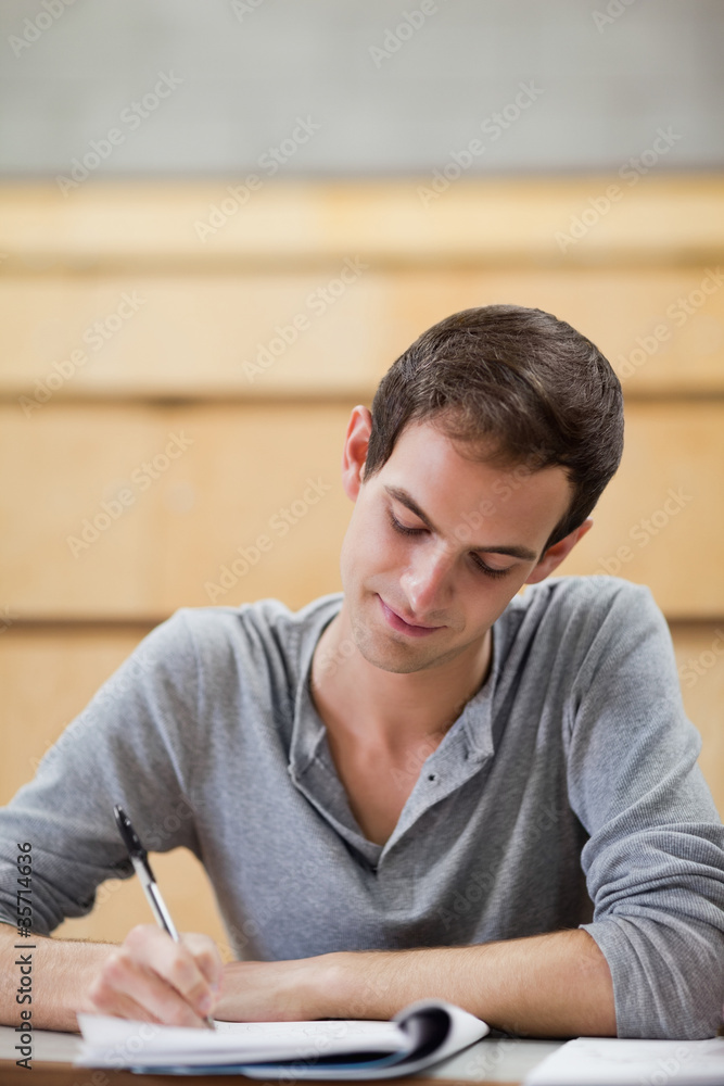 Portrait of a male student writing on a notepad Portrait of a male student writing on a notepad