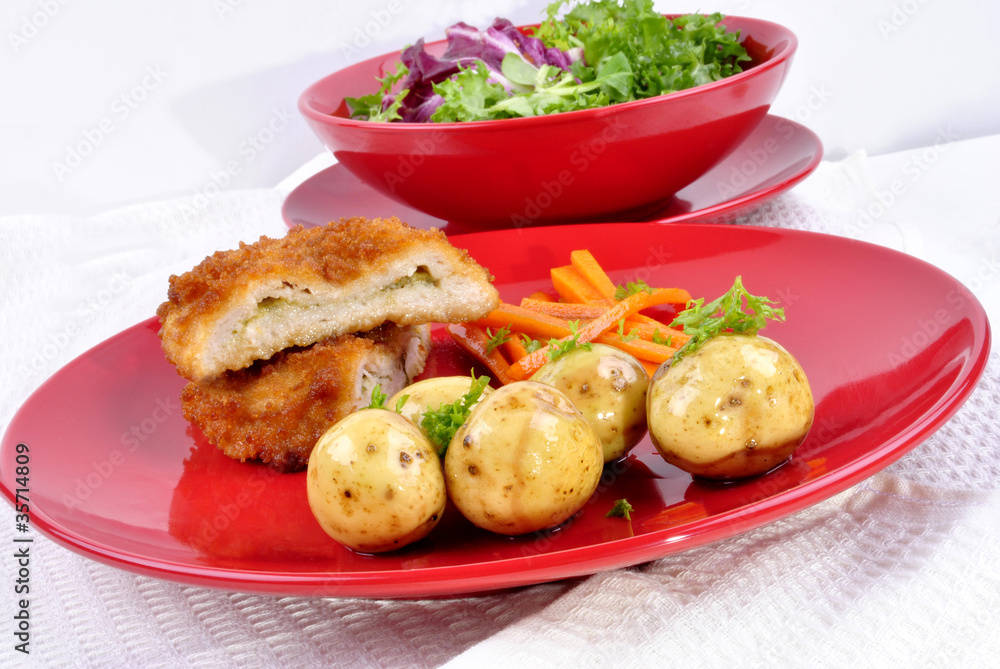 Chicken Kiev mit jungen Kartoffeln, Karotten-Streifen und frisch Chicken Kiev mit jungen Kartoffeln, Karotten-Streifen und frisch