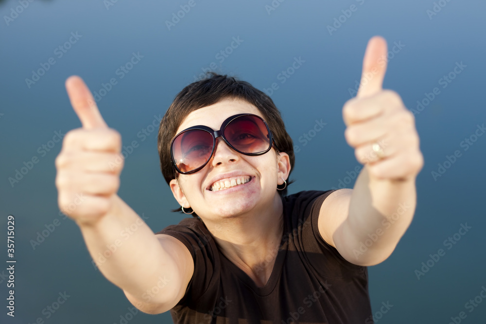 Young brunette girl making thumbs up gesture Young brunette girl making thumbs up gesture