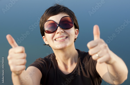 Young brunette girl making thumbs up gesture