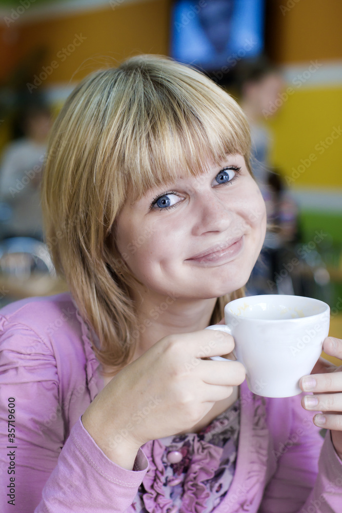 Young pretty girl sits with a cup of coffee Young pretty girl sits with a cup of coffee