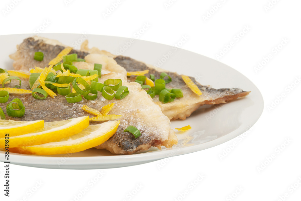 Two pieces of fried fish and lemon segment
