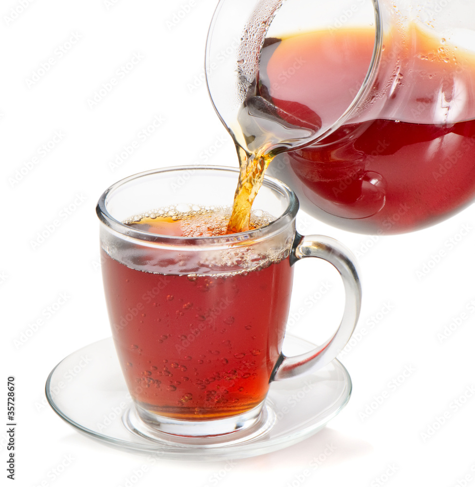 Tea being poured into tea cup isolated on a white background Tea being poured into tea cup isolated on a white background