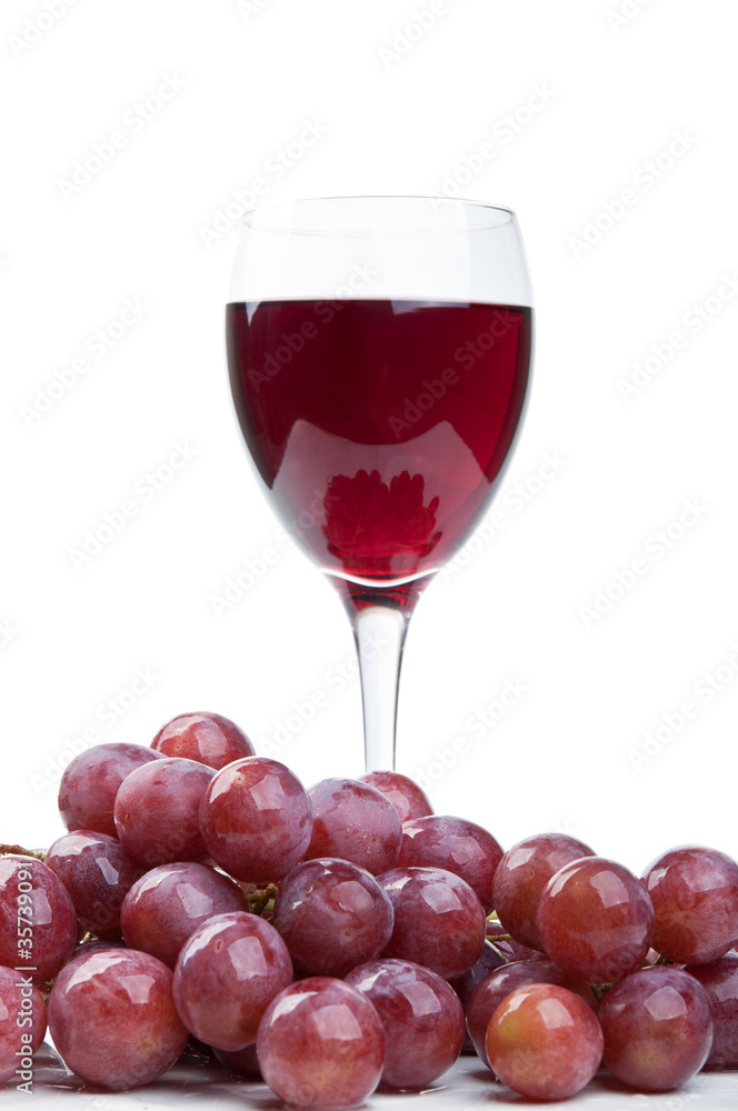 a glass of wine and red grapes a glass of wine and red grapes