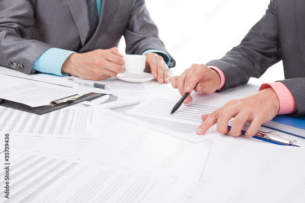Business people in elegant suits sitting at desk handshake Business people in elegant suits sitting at desk handshake