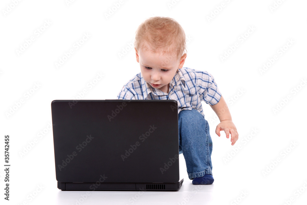 Little boy sitting with laptop over white background Little boy sitting with laptop over white background
