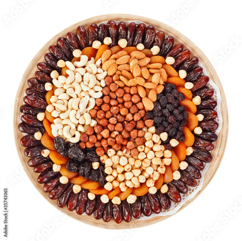 Many dried fruits on a round plate with hazel, cashew nuts, prun photo