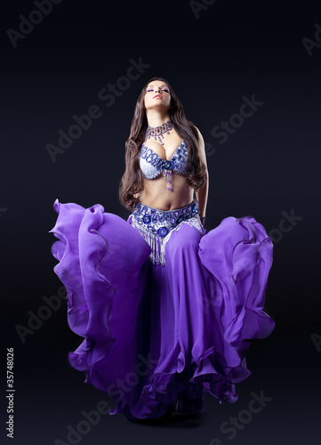 beauty dancer posing in dark with fly purple veil