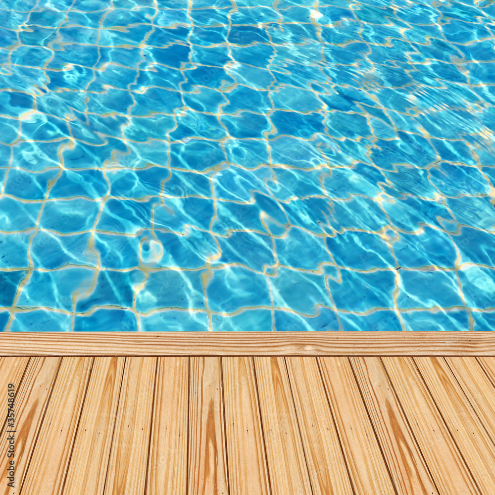 Wooden floor beside the blue swimming pool