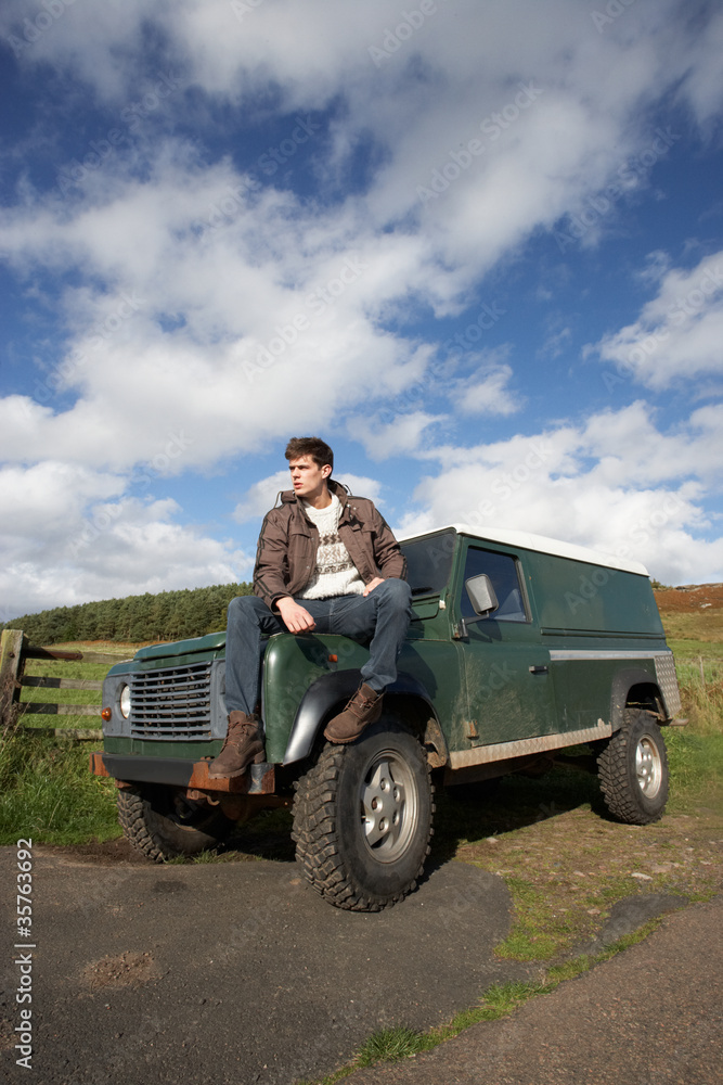 Fototapeta premium Young man in countryside with SUV