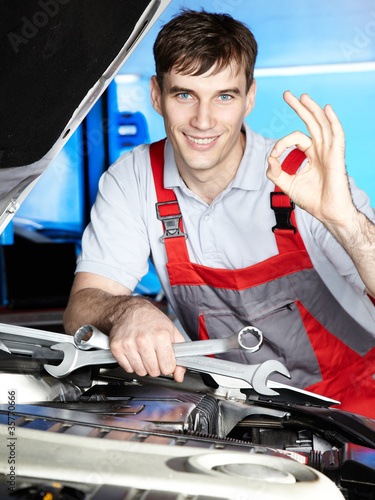 Master mechanic is satisfied with his job in a garage photo