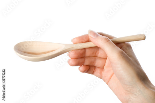 Woman holding wooden spoon in the hand photo