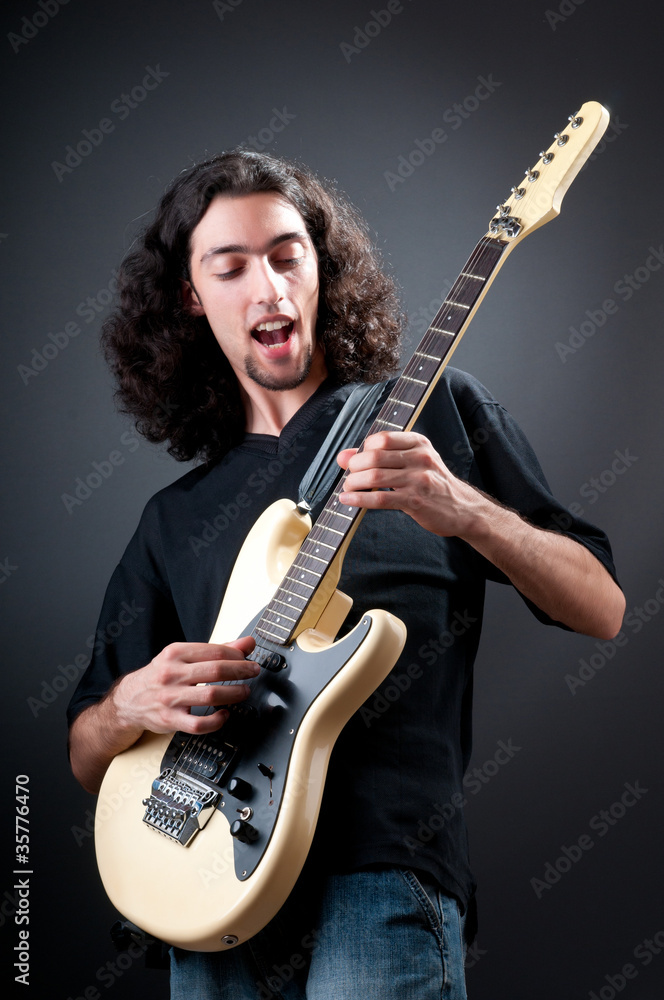 Obraz premium Guitar player against the dark background