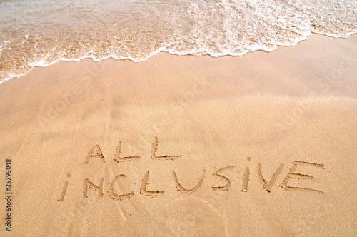 All inclusive text written on the beach sand