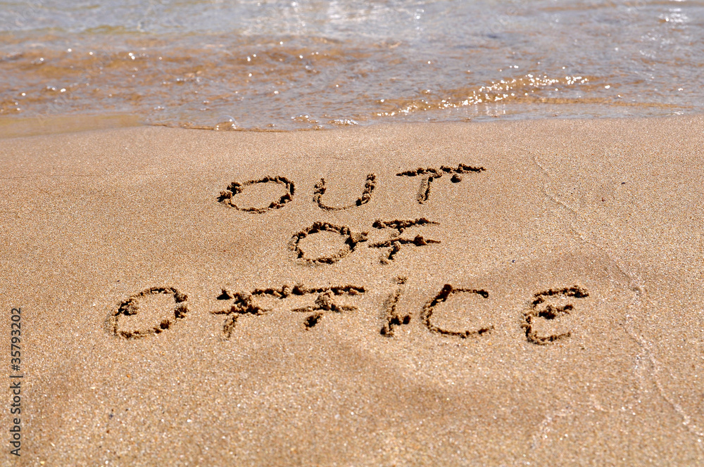 Fototapeta premium Out of office text written on the beach sand