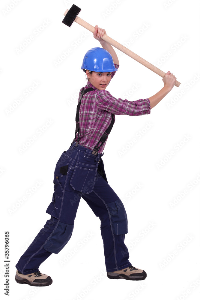 Young woman laborer using hammer isolated on white background Young woman laborer using hammer isolated on white background