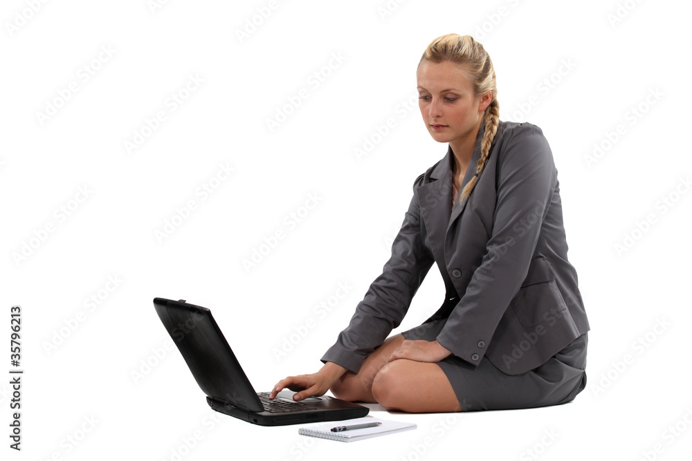 Businesswoman sitting on the floor with her laptop Businesswoman sitting on the floor with her laptop