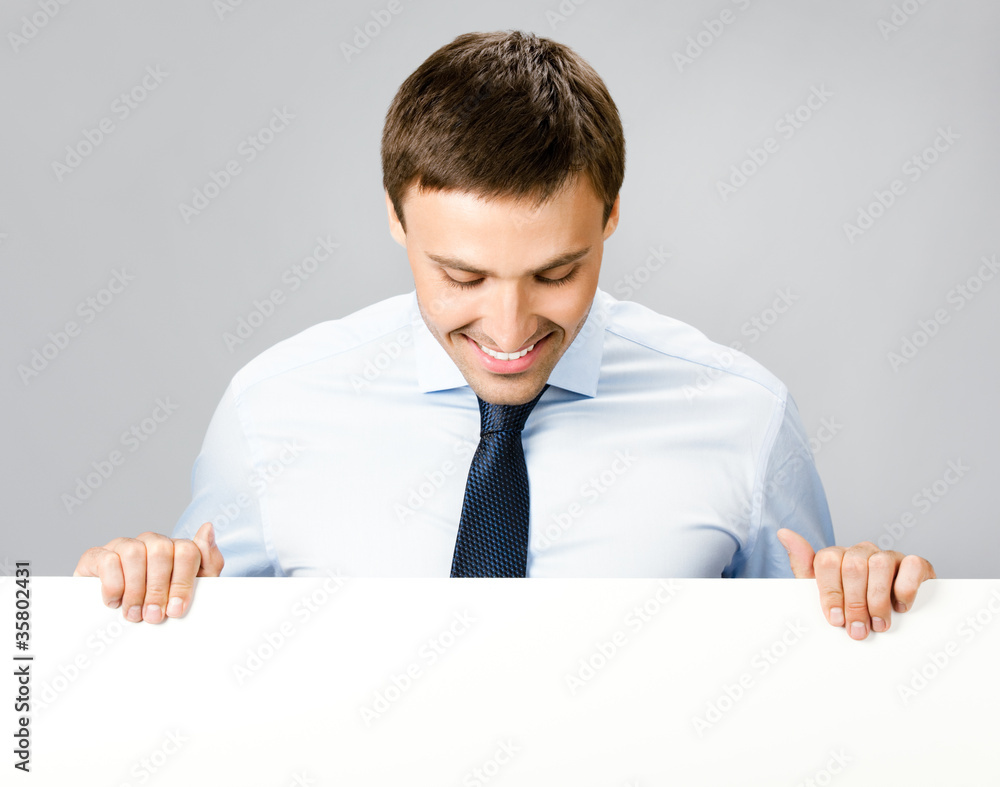 Business man showing blank signboard, over gray Business man showing blank signboard, over gray