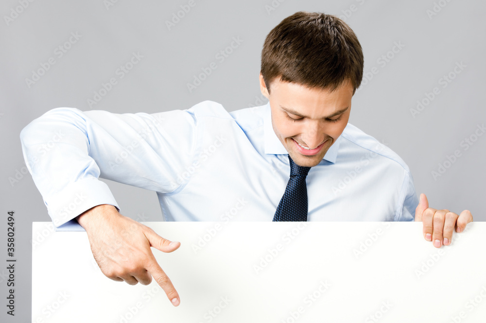 Business man showing blank signboard, over gray Business man showing blank signboard, over gray