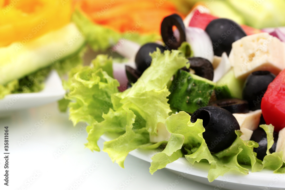 Tasty greek salad on plate isolated on white Tasty greek salad on plate isolated on white