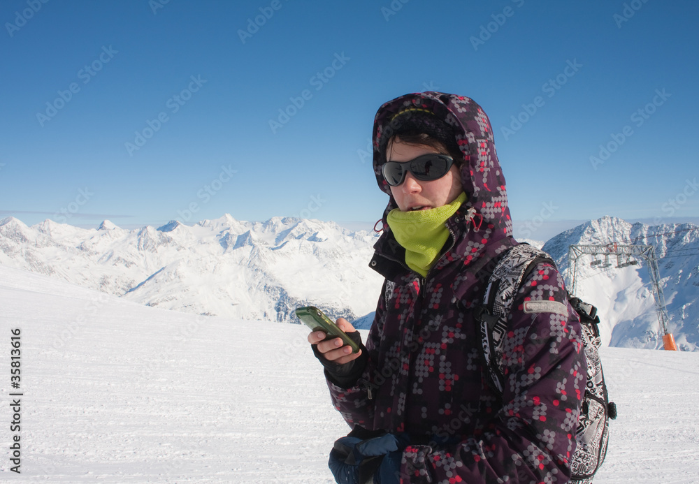 Skier in the mountains with a mobile phone in his hand Skier in the mountains with a mobile phone in his hand