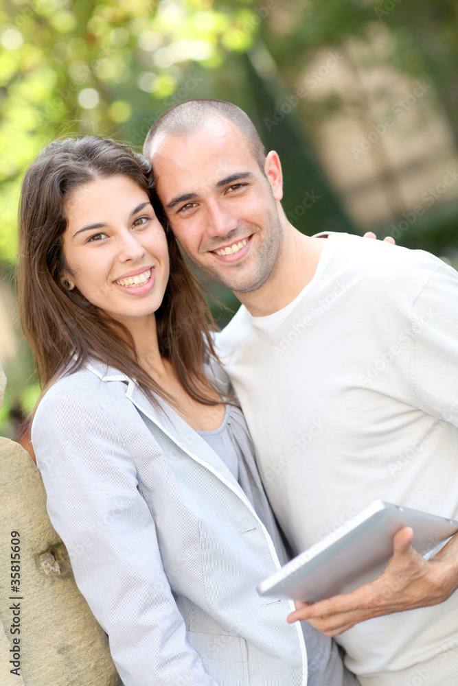 Young couple in public park with electronic tablet Young couple in public park with electronic tablet