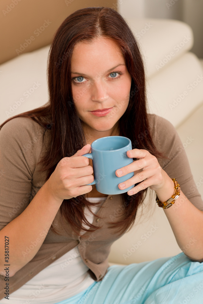 Attractive woman sitting on modern home sofa Attractive woman sitting on modern home sofa