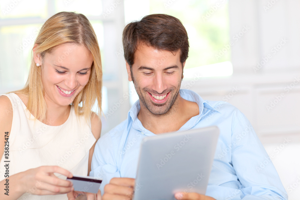 Young couple at home doing online shopping Young couple at home doing online shopping