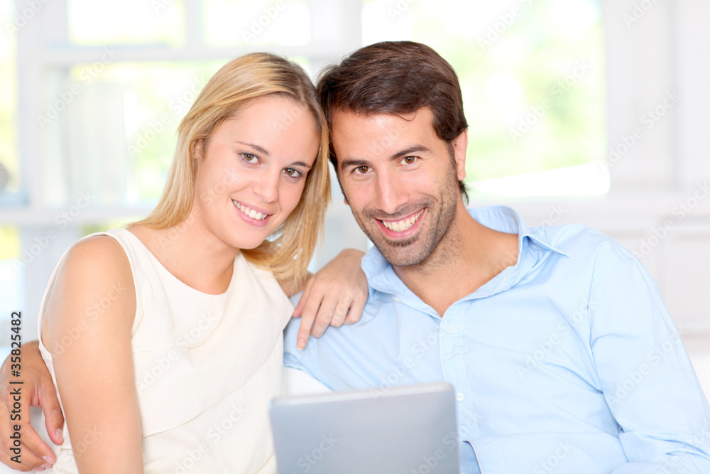Young couple using electronic tablet at home Young couple using electronic tablet at home