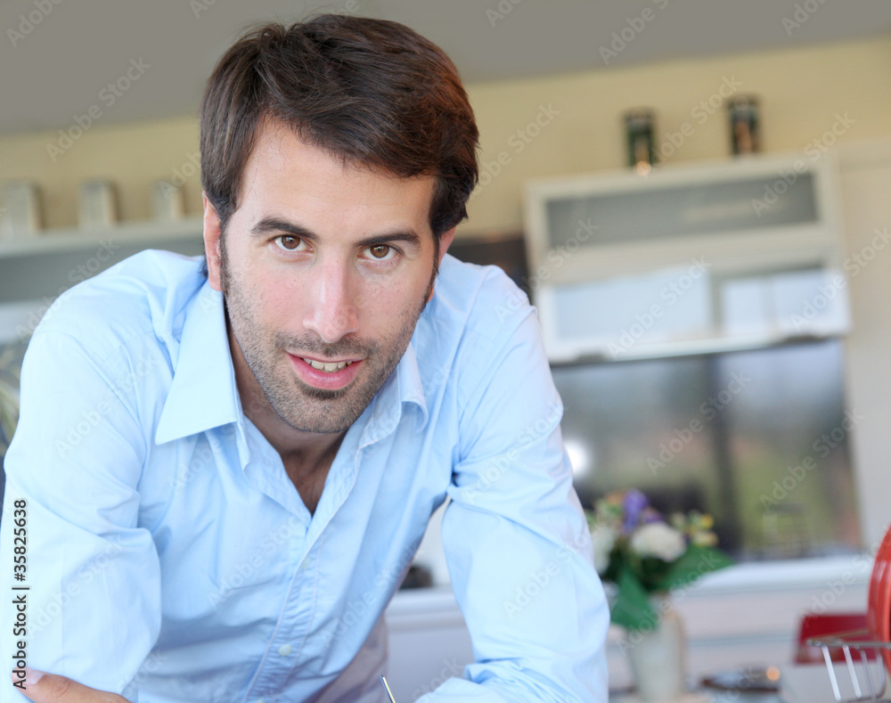Fototapeta premium Smiling man standing in domestic kitchen