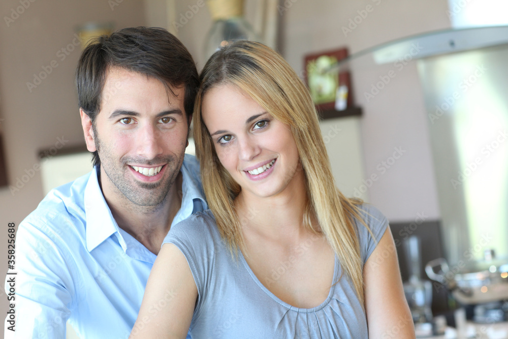 Happy young couple standing in home kitchen Happy young couple standing in home kitchen