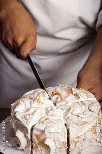 Cuisinier coupant un vacherin meringué photo