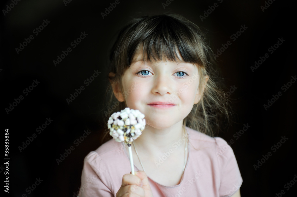 Naklejka premium Funny child girl showing a marshmallow cake