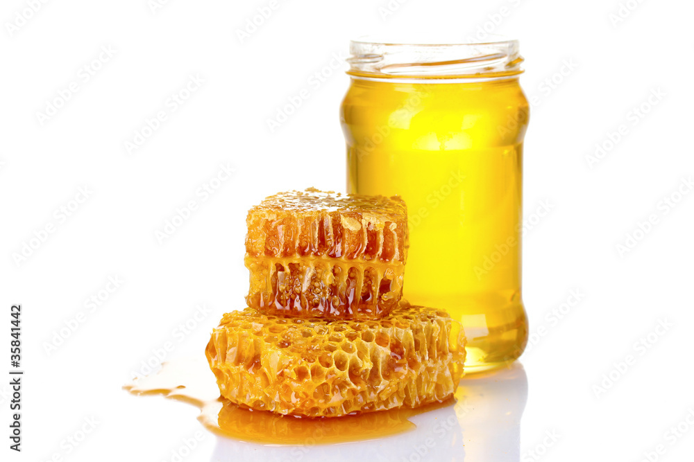 Beautiful combs, spoon and honey in jar isolated on white Beautiful combs, spoon and honey in jar isolated on white