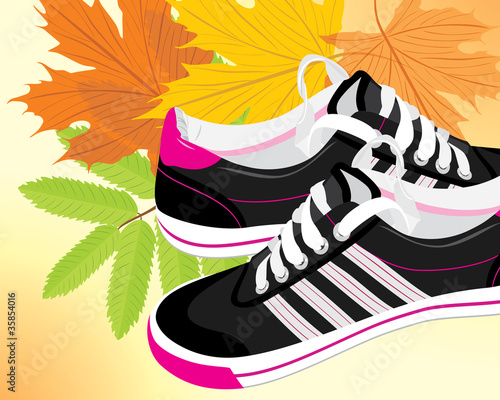 Pair of black sneakers on the autumn background