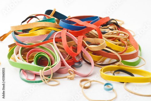 Assortment of rubber bands piled against white background