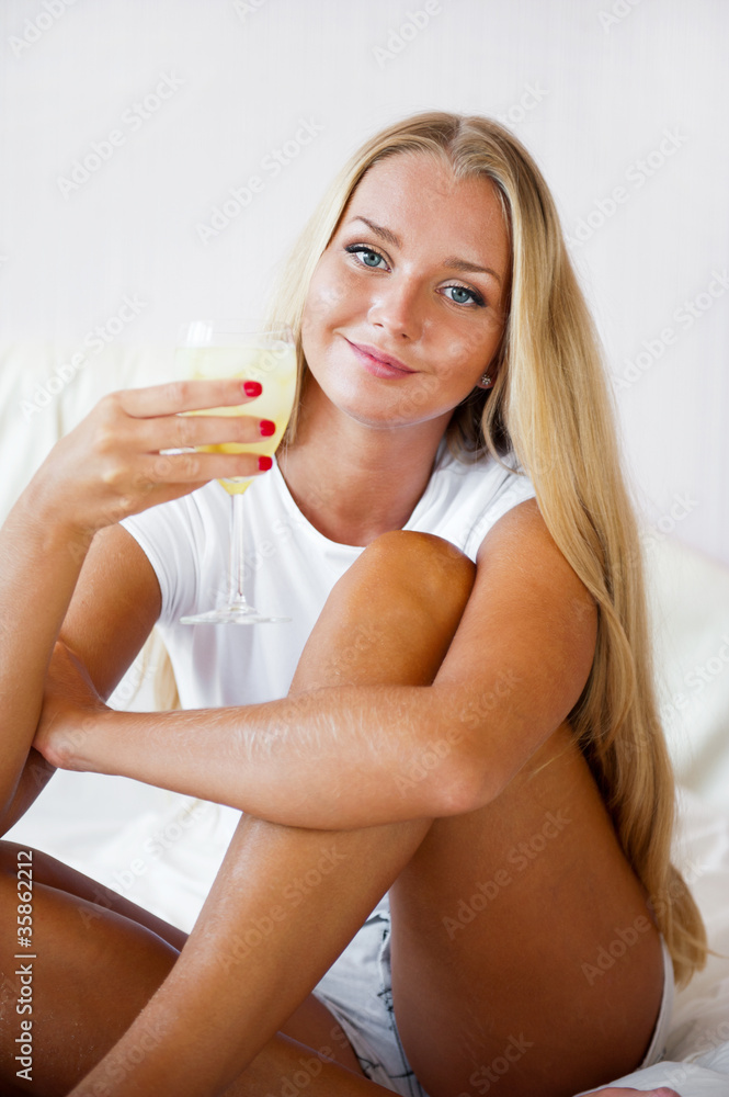 Woman drinking fresh ice tea beverage and looking at camera whil Woman drinking fresh ice tea beverage and looking at camera whil