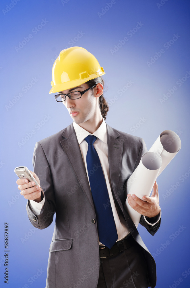 Young architect with drawings and hardhat Young architect with drawings and hardhat