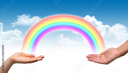 Male and female hand holding a rainbow