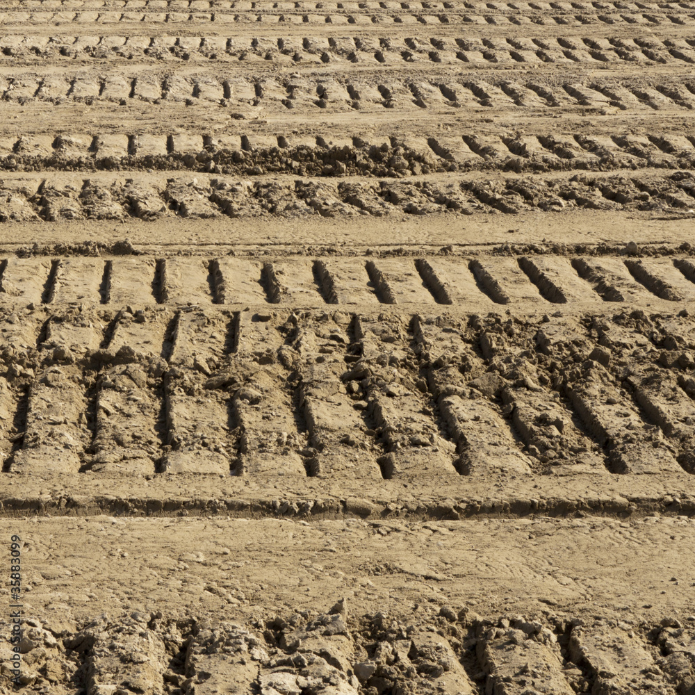 Spuren von schweren Kettenfahrzeugen im Sand einer Baustelle Spuren von schweren Kettenfahrzeugen im Sand einer Baustelle
