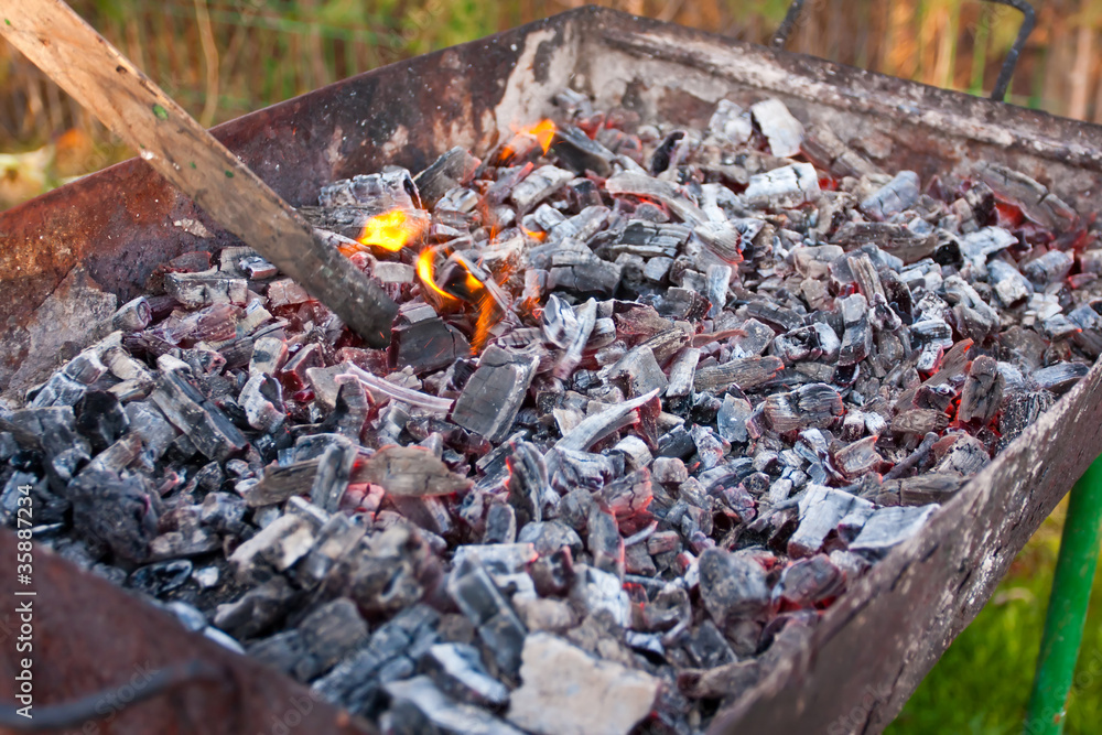 A grill with charcoal and flames A grill with charcoal and flames
