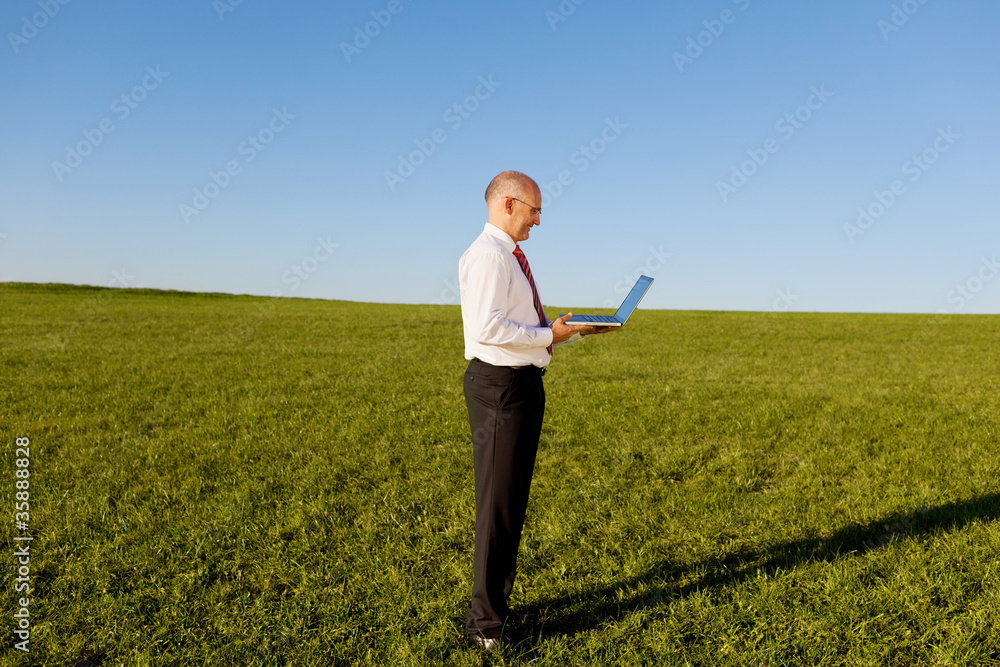 mann mit laptop auf einer wiese mann mit laptop auf einer wiese